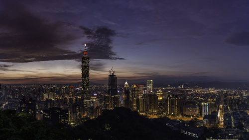 Illuminated cityscape against sky at night