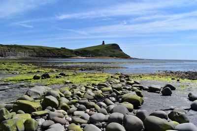 Scenic view of rocks on beach against sky