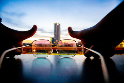 Close-up of hand holding umbrella against sky