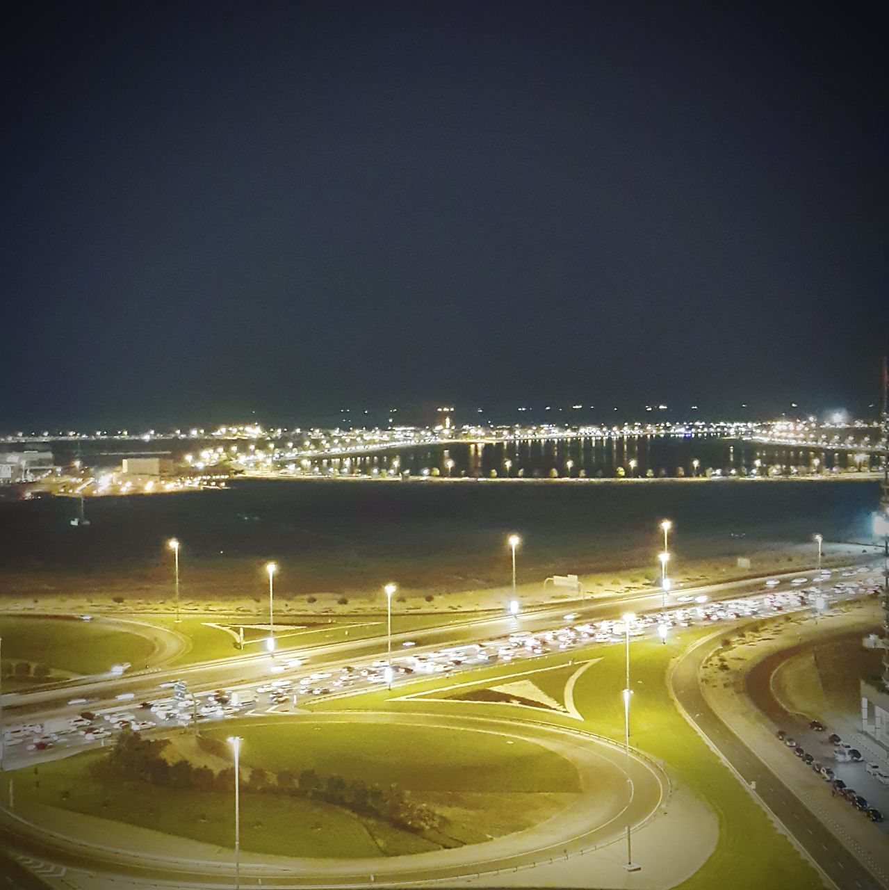 illuminated, night, city, connection, transportation, built structure, architecture, bridge - man made structure, high angle view, road, light trail, street light, clear sky, copy space, river, cityscape, sky, outdoors, bridge, engineering