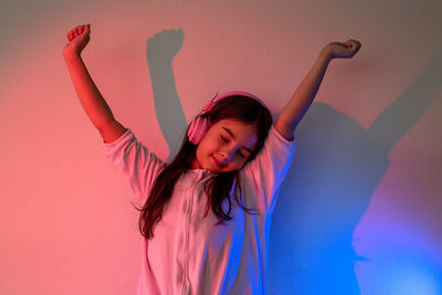 A dancing little girl in pink headphones