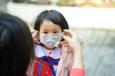 Schoolgirl wearing n95 mask to prevent deadly virus and air pollution.