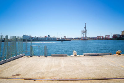 Scenic view of harbor against clear blue sky