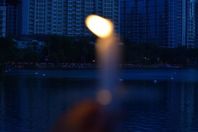 Reflection of woman on river in city at night