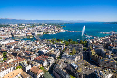 High angle view of buildings and sea against blue sky