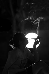 Rear view of girl sitting on table