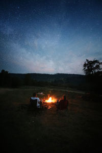 Bonfire on field against sky at night