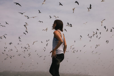 Full length rear view of woman flying birds