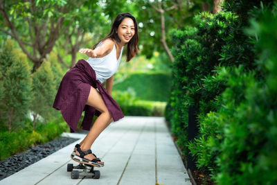 Young woman smiling while sitting on plants