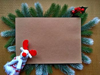 Christmas background for postcard. craft paper on fir branches with christmas decor and deer