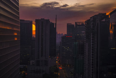 Modern buildings against sky during sunset in city