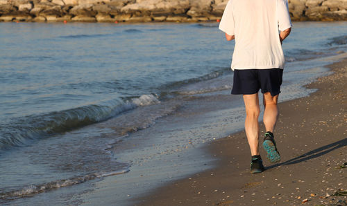 Low section of woman standing on beach