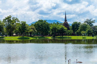 Scenic view of lake by trees against sky