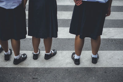 Low section of schoolgirls standing on street