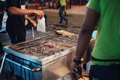 Midsection of man standing on barbecue grill