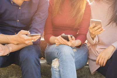 Midsection of woman using mobile phone