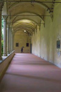 Rear view of man walking in corridor of building