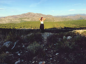 Woman standing on mountain against sky