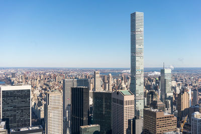 Skyscrapers in city against clear blue sky