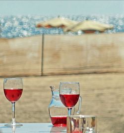 Close-up of beer on table against sea