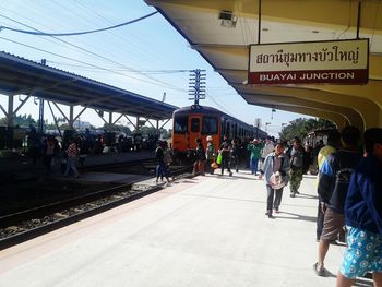 People at railroad station against sky