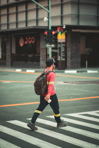 Rear view of woman with umbrella on street in city