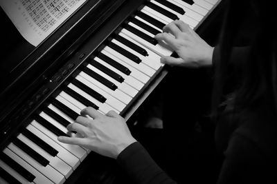 Cropped image of pianist playing piano indoors