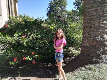 Girl standing against plants