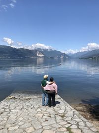 Rear view of couple on lake against sky