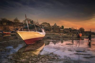 Boats in sea at sunset