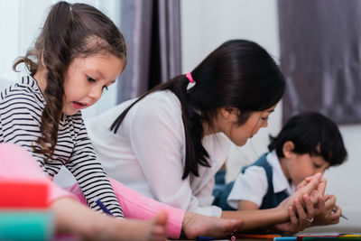 Mother assisting kids in homework at home