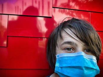 Portrait of mid adult woman against red wall