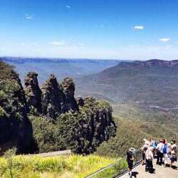 People walking on mountain against sky