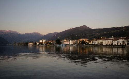 Scenic view of lake by buildings against clear sky