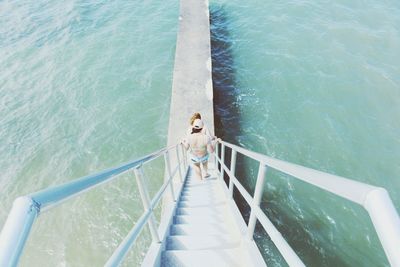 High angle view of woman walking on staircase at beach