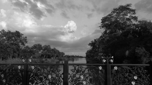 Trees by lake against sky