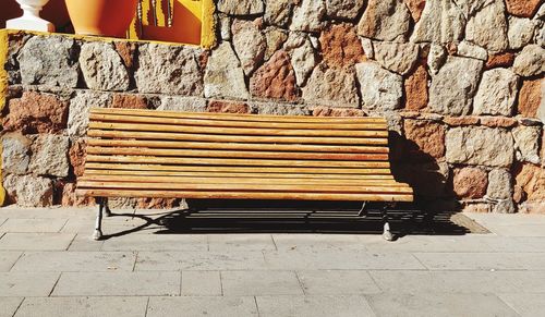 Empty bench against wall