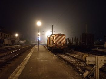 Train on railroad station platform at night