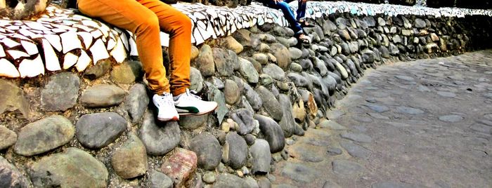 Full length of woman standing on stone wall