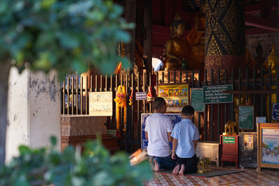 Rear view of people at temple against building