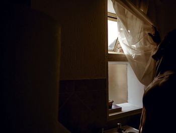 Close-up of woman standing by window at home