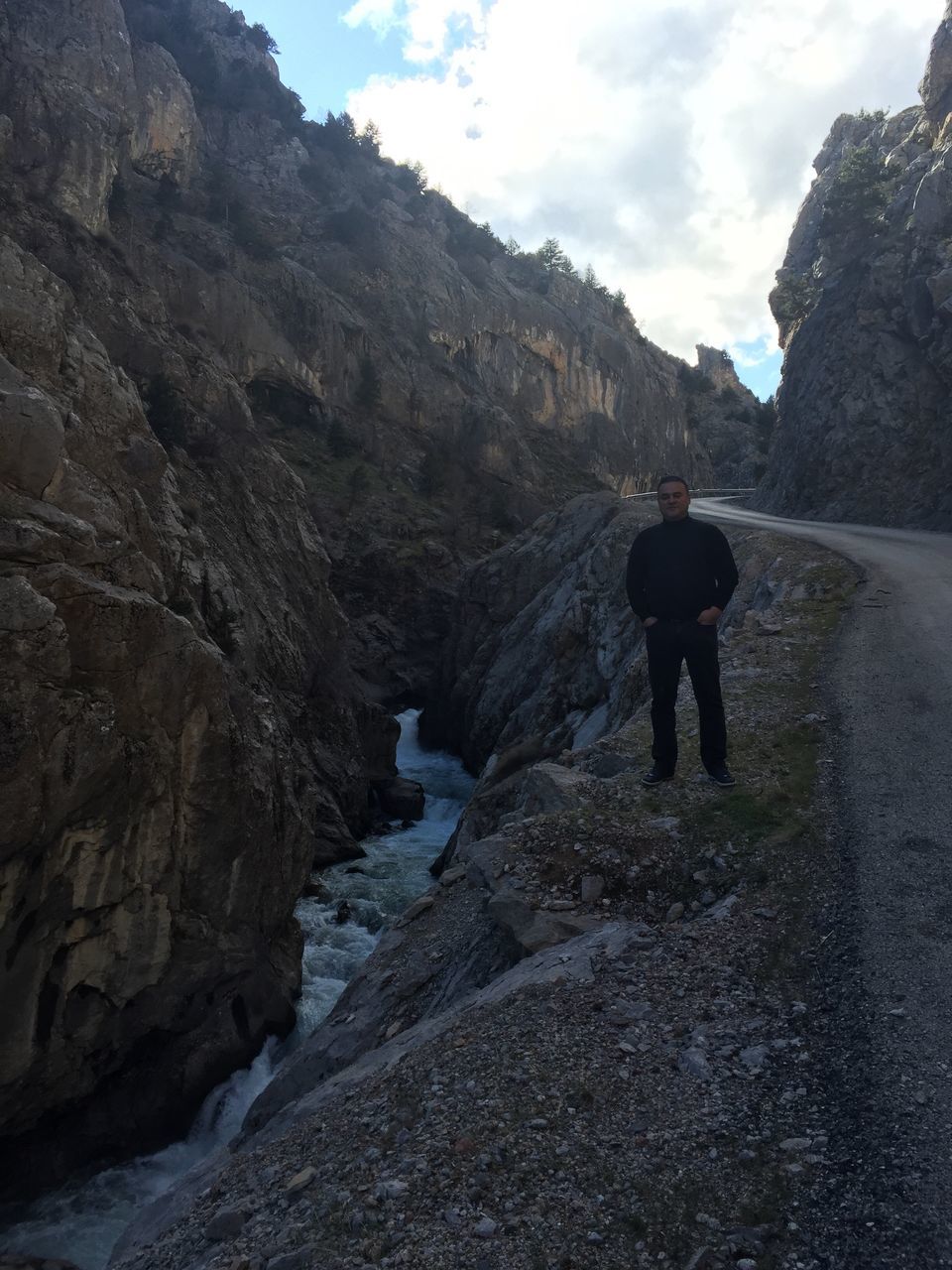 mountain, lifestyles, leisure activity, full length, rear view, sky, men, standing, tranquil scene, walking, mountain range, scenics, nature, rock - object, beauty in nature, tranquility, hiking, cloud - sky