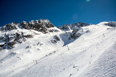 Scenic view of snowcapped mountains against blue sky