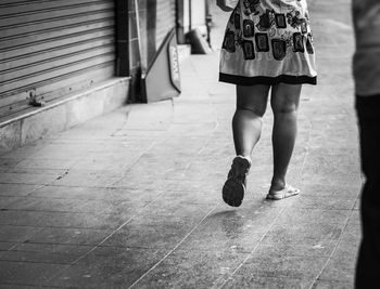 Low section of woman walking on footpath