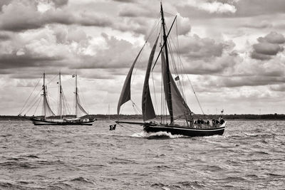 Sailboat sailing on sea against sky