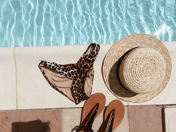 High angle view of personal accessories by swimming pool during summer