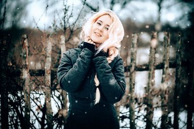 Young woman looking at tree during winter