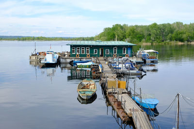 Fishing boats moored in lake against sky