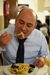 Close-up of man eating food in restaurant