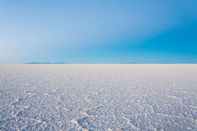 Scenic view of desert against clear blue sky